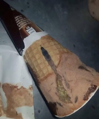 Hoy, mi hija abrió su helado de chocolate favorito, el mismo que come casi todos los días después de la escuela. Todo estaba como siempre: un cono crujiente, un aroma dulce, una suave capa de chocolate encima. Pero unos segundos después, la oí decir sorprendida: “¡Mamá, mira qué es esto!”. Me acerqué y vi algo extraño y oscuro dentro, como un trozo de envoltorio o caramelo. Al principio, pensamos que era solo un defecto, luego que tal vez se había metido un trozo de chocolate. Pero mi hija, siempre curiosa, decidió rebuscar con cuidado con una cuchara. Un momento después, gritó. Dentro, justo debajo del chocolate, vimos…