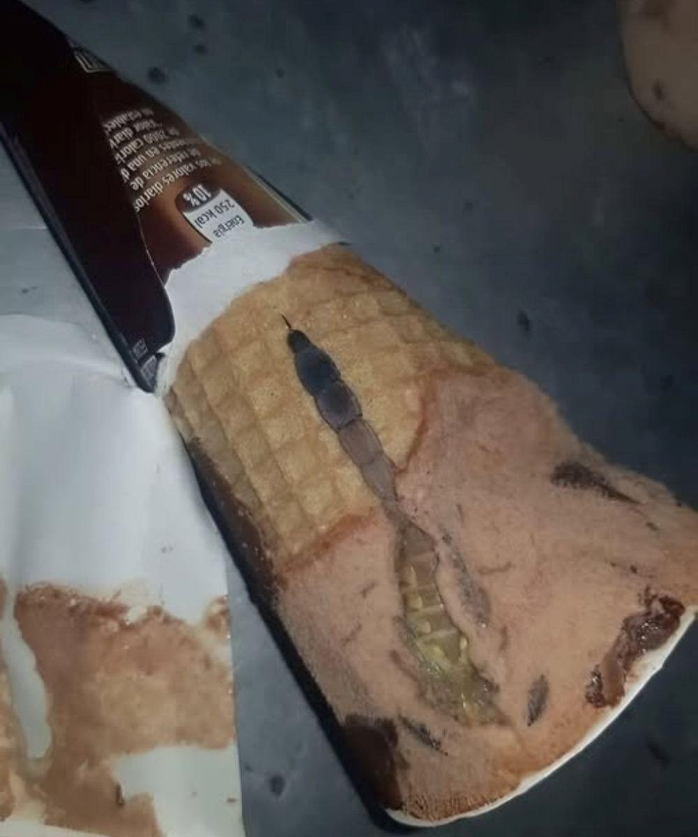 Hoy, mi hija abrió su helado de chocolate favorito, el mismo que come casi todos los días después de la escuela. Todo estaba como siempre: un cono crujiente, un aroma dulce, una suave capa de chocolate encima. Pero unos segundos después, la oí decir sorprendida: “¡Mamá, mira qué es esto!”. Me acerqué y vi algo extraño y oscuro dentro, como un trozo de envoltorio o caramelo. Al principio, pensamos que era solo un defecto, luego que tal vez se había metido un trozo de chocolate. Pero mi hija, siempre curiosa, decidió rebuscar con cuidado con una cuchara. Un momento después, gritó. Dentro, justo debajo del chocolate, vimos…
